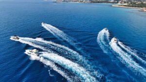 A convoy of yachts creating a synchronized pattern of wakes on the serene blue waters near Ayia Napa.