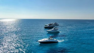 Luxurious white yachts in formation cruising the sparkling turquoise Mediterranean Sea off Ayia Napa's coast.