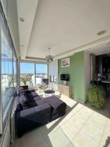 Modern living area with floor-to-ceiling windows offering panoramic views of Ayia Napa bay in Cyprus