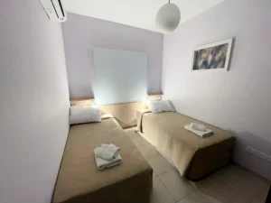 Cozy bedroom with twin beds and soft lighting in Ayia Napa, ideal for a restful sleep in a shared space.