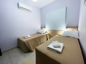 A calm and inviting twin bedroom with muted colors and essential comforts in Ayia Napa, ensuring a tranquil rest.