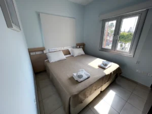 Comfortable bedroom with natural light in Ayia Napa, Cyprus, with a choice of double or single beds and a view of the sea.