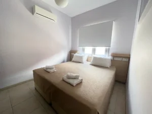 Minimalist and serene bedroom in Ayia Napa, Cyprus, with adaptable bedding arrangement and a calming ambiance.