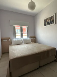 Comfortable bedroom with a double bed, simple decor, and lavender walls in Ayia Napa, close to central amenities and attractions.