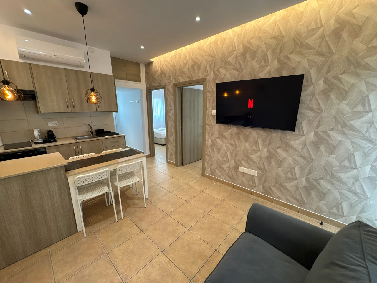 Open-plan kitchen, dining area, and living space with a TV in our holiday apartment in Ayia Napa, Cyprus.