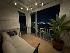 Balcony with outdoor seating and string lights at night in the Charming Central Apartment with Sea View Balcony, Ayia Napa, Cyprus.