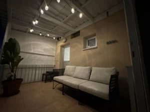 Balcony with a comfortable sofa and string lights at night in the Charming Central Apartment with Sea View Balcony, Ayia Napa, Cyprus.