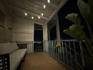 Balcony with a sofa, string lights, and a view of the night sky in the Charming Central Apartment with Sea View Balcony, Ayia Napa, Cyprus.