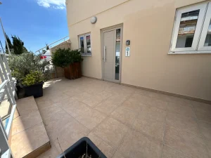 Entrance area with a door and plants at the Charming Central Apartment with Sea View Balcony, Ayia Napa, Cyprus.