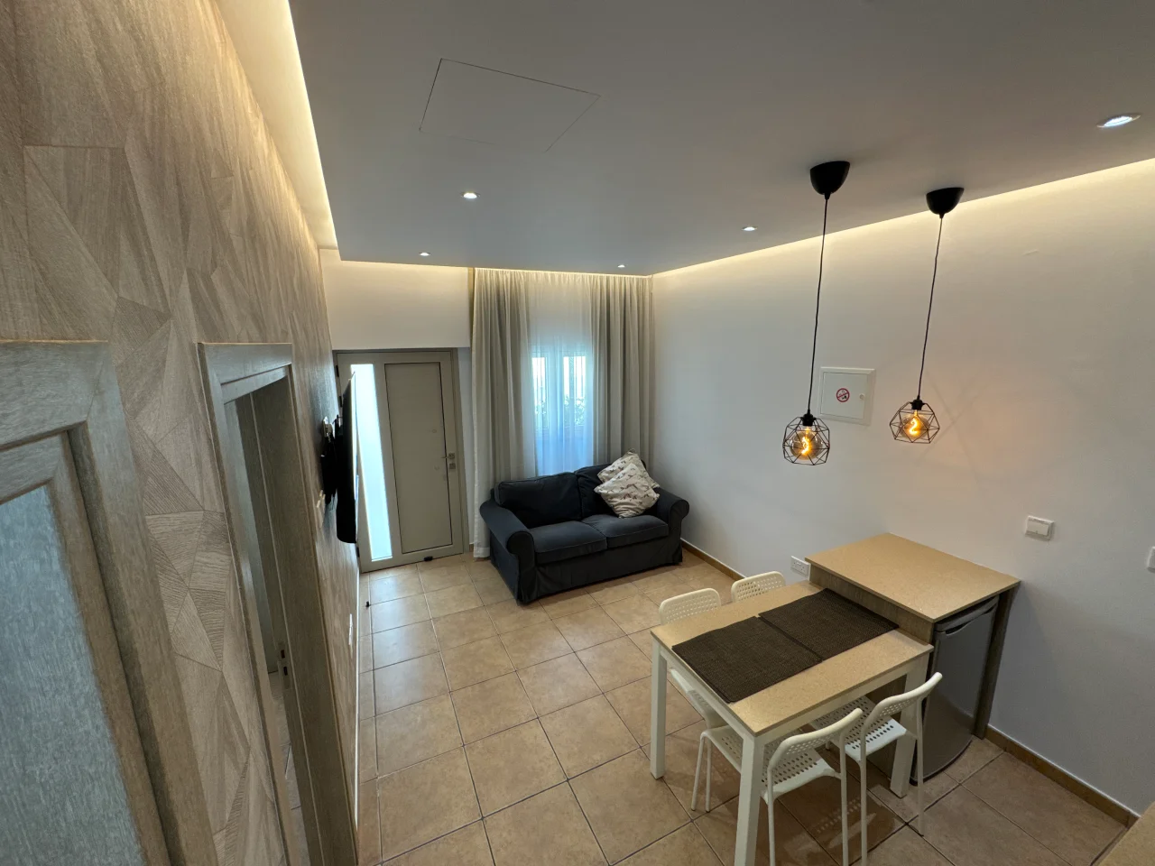 Comfortable living area with a sofa, dining table, and chairs in our holiday apartment in Ayia Napa, Cyprus.