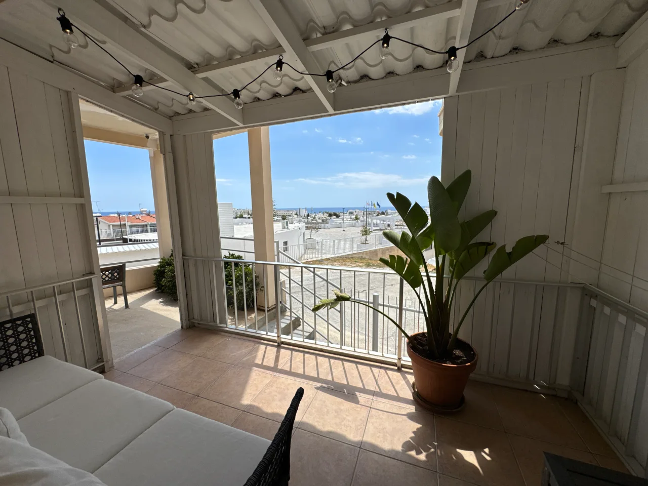 Balcony with seating area and a view of the sea from Charming Central Apartment, a two-bedroom holiday rental near Grecian Bay in Ayia Napa, Cyprus.