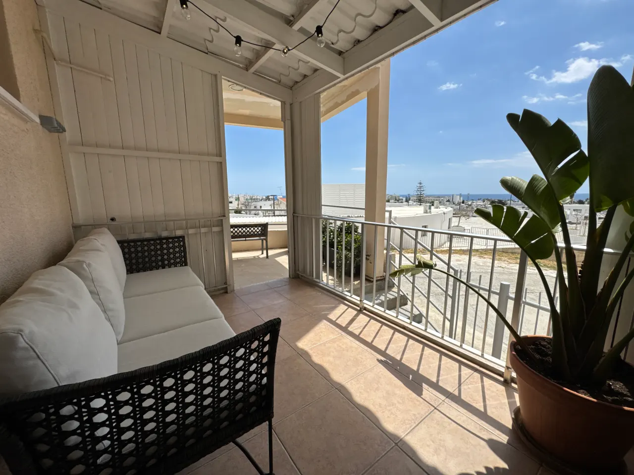 Balcony with seating and a view of the sea from Charming Central Apartment, a two-bedroom holiday rental near Grecian Bay in Ayia Napa, Cyprus.