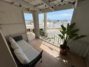 Balcony with seating and a view of the sea from Charming Central Apartment, a two-bedroom holiday rental near Grecian Bay in Ayia Napa, Cyprus.