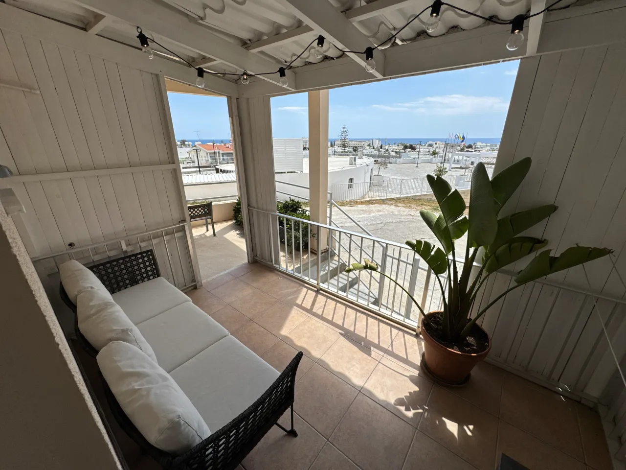 Balcony with seating and a view of the sea from Charming Central Apartment, a two-bedroom holiday rental near Grecian Bay in Ayia Napa, Cyprus.